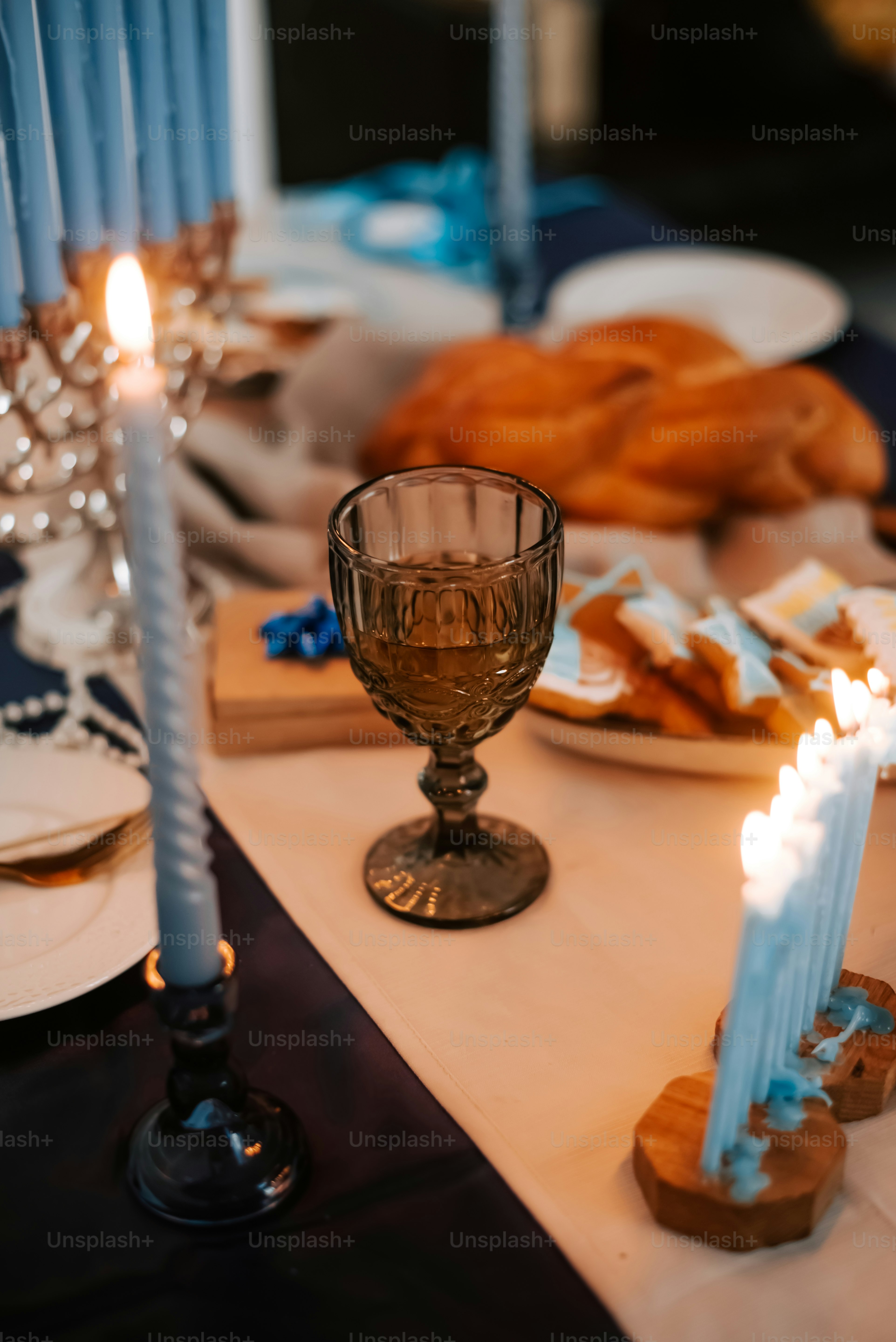 a table topped with plates of food and candles