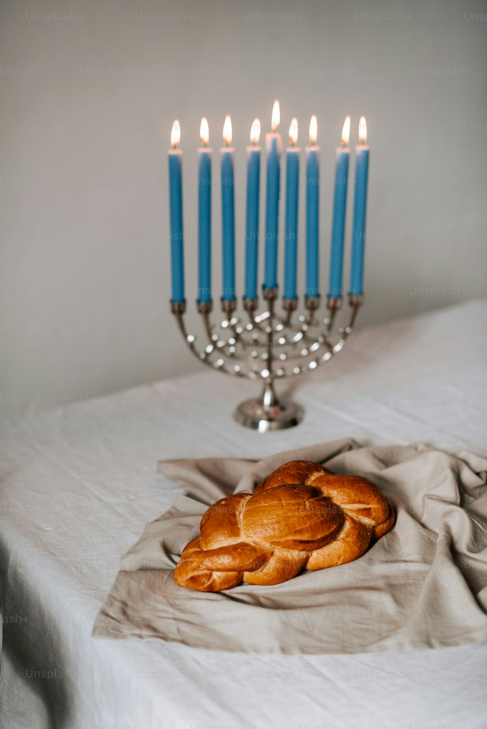 a table topped with a croissant and a candelabra