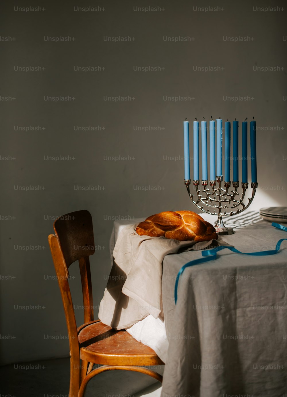 a table topped with a table cloth and a lit menorah