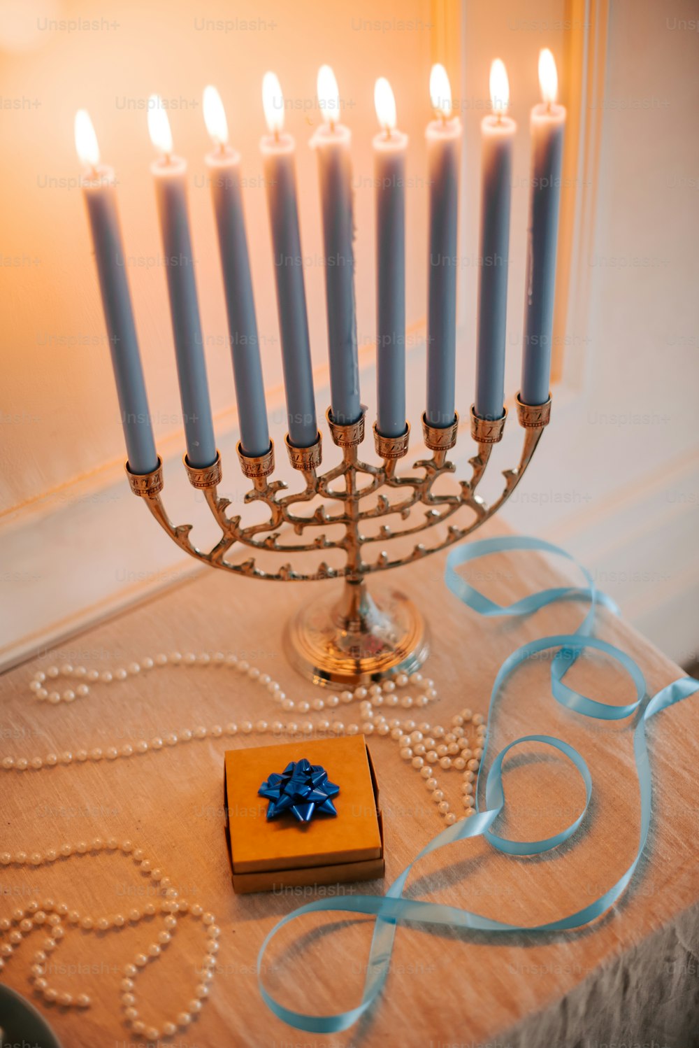 a menorah with candles and a gift box on a table