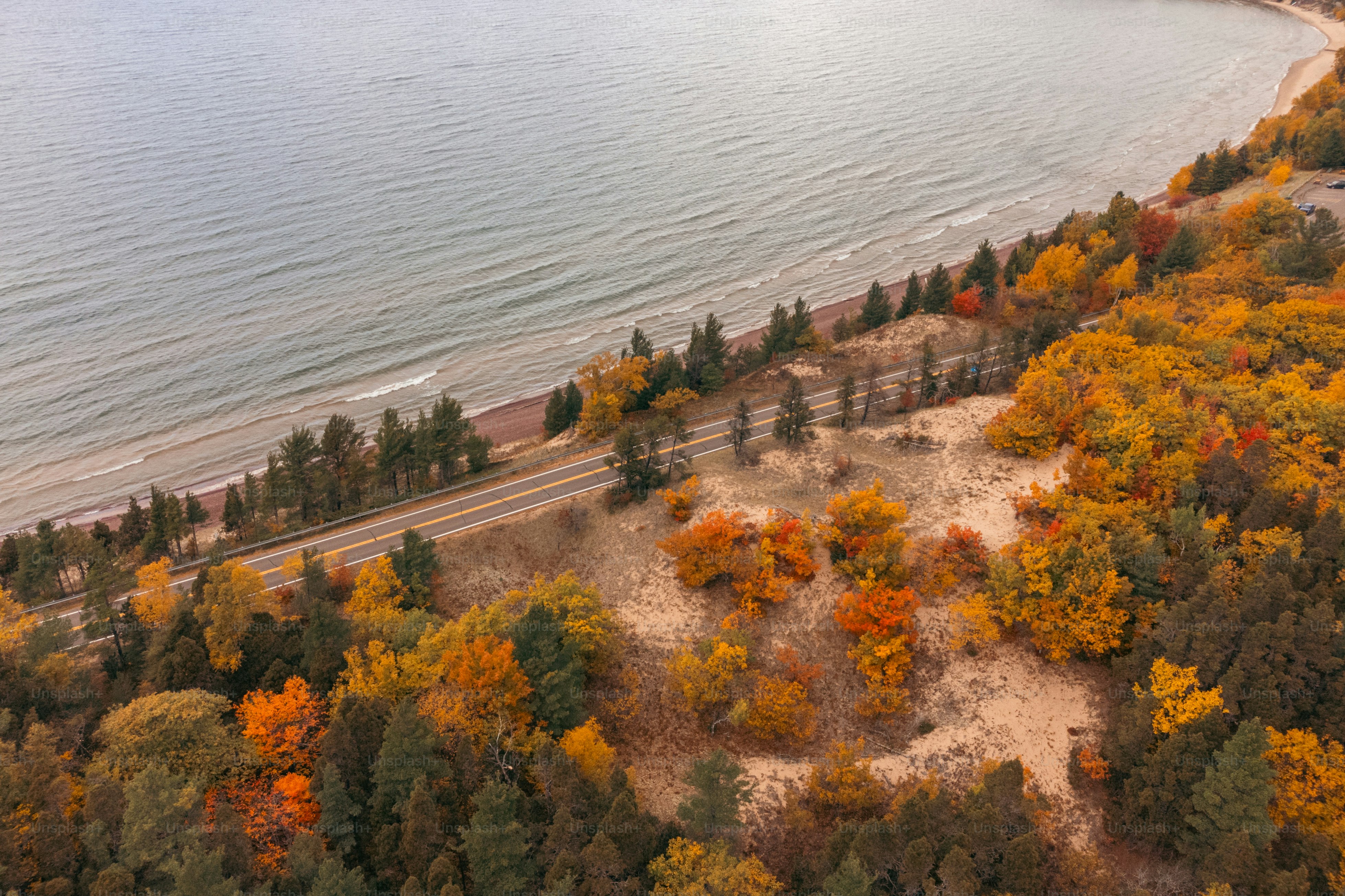 uma vista aérea de uma estrada perto de um corpo de água