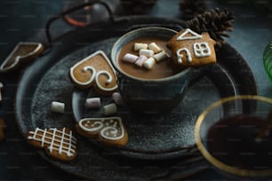 una taza de chocolate caliente con malvaviscos y galletas de jengibre