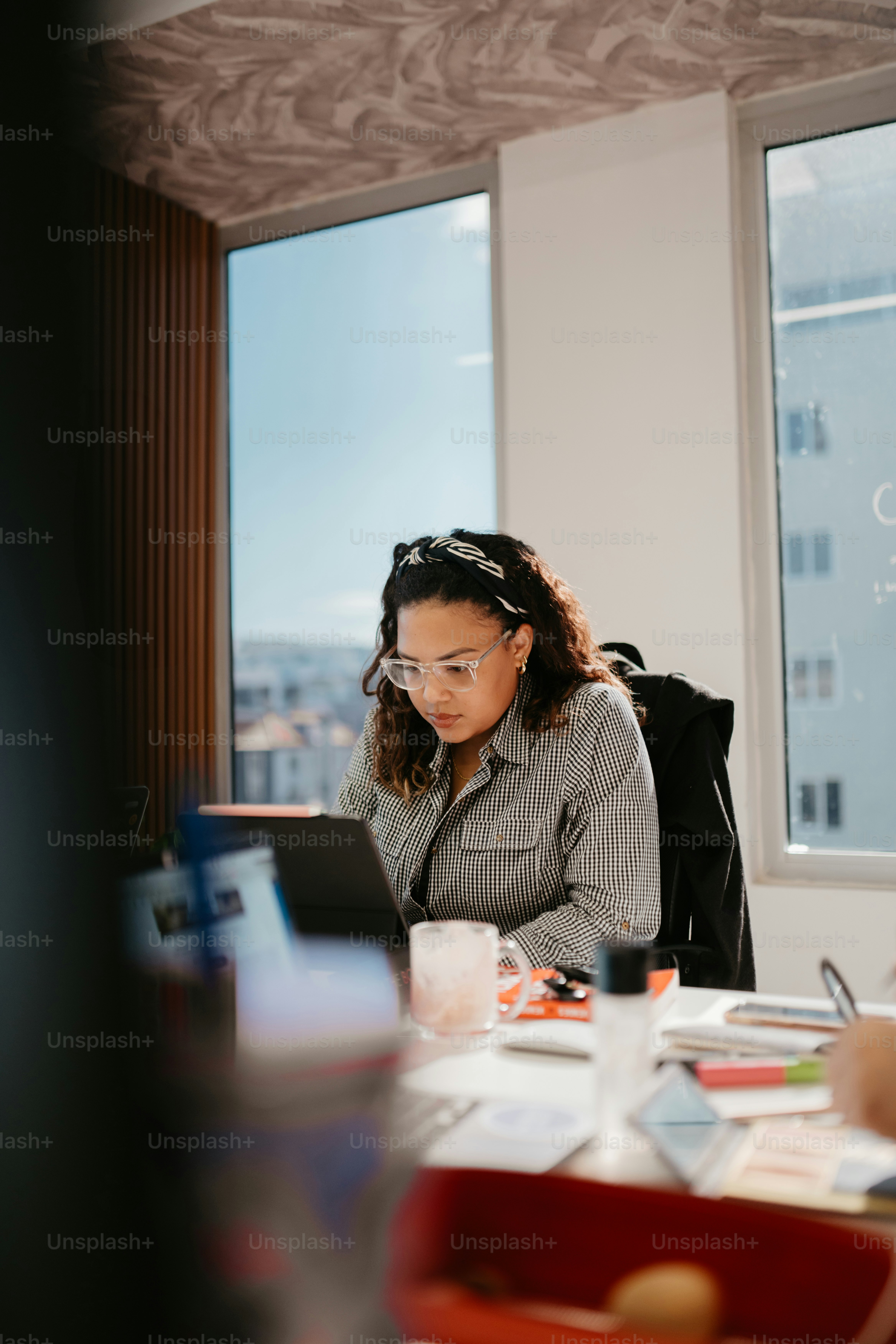 A woman sitting at a desk using a laptop computer photo – Office Image ...