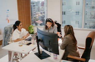 a group of people sitting around a computer