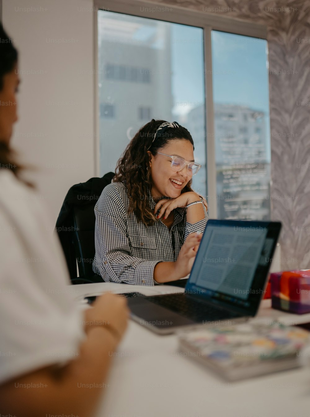 a woman sitting in front of a laptop computer