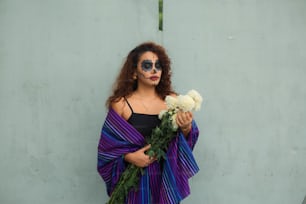a woman with makeup on holding a bouquet of flowers