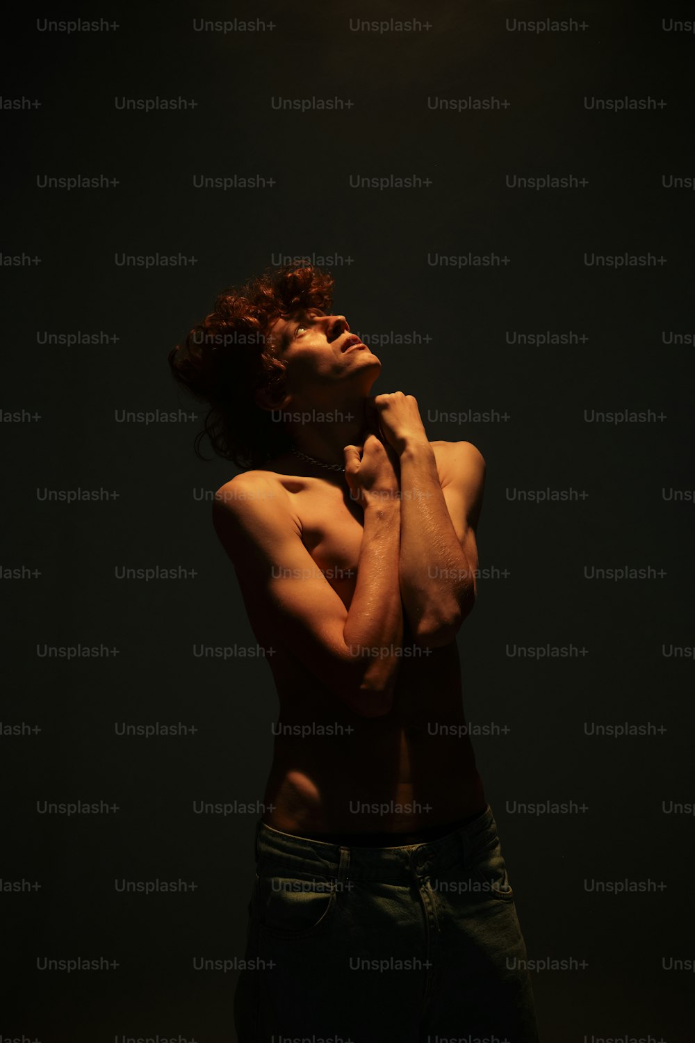 a shirtless man standing in a dark room