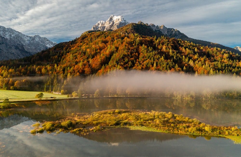 a lake surrounded by a mountain covered in fog