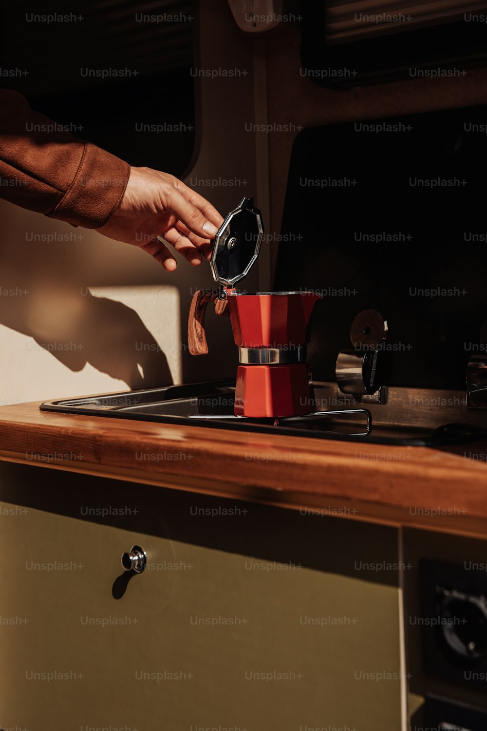 a person pours coffee into a red coffee pot