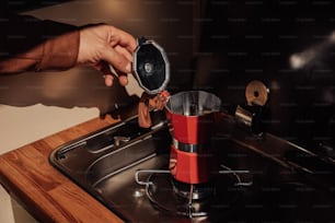 a person is putting something in a coffee maker