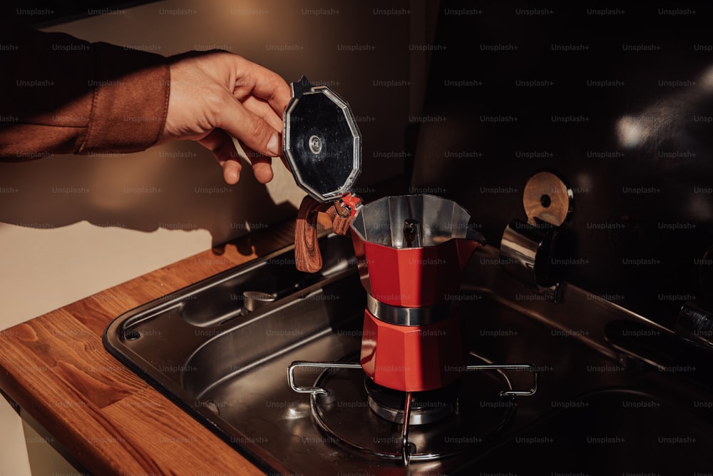 a person is putting something in a coffee maker