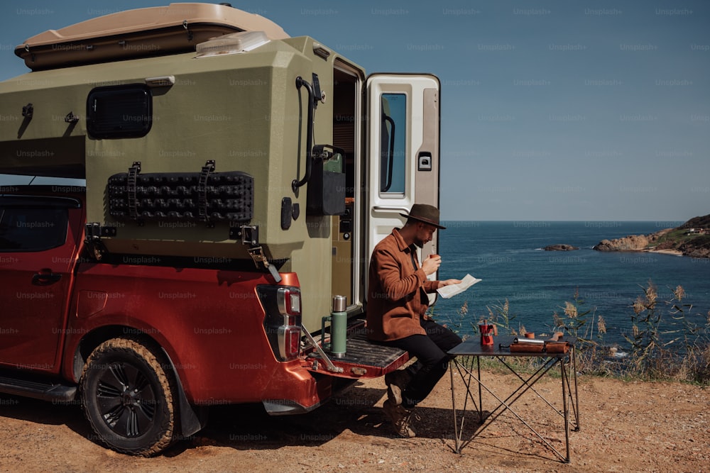 a man sitting in a truck reading a paper