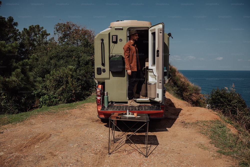 a man standing in the open door of a vehicle