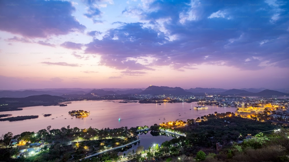 Ville d’Udaipur au lac Pichola dans la soirée, Rajasthan, Inde. Vue depuis le point de vue de la montagne, voir toute la ville se refléter sur le lac.