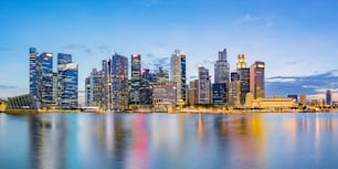 Horizonte del distrito financiero de Singapur en la bahía de Marina en el crepúsculo, ciudad de Singapur, sudeste asiático.