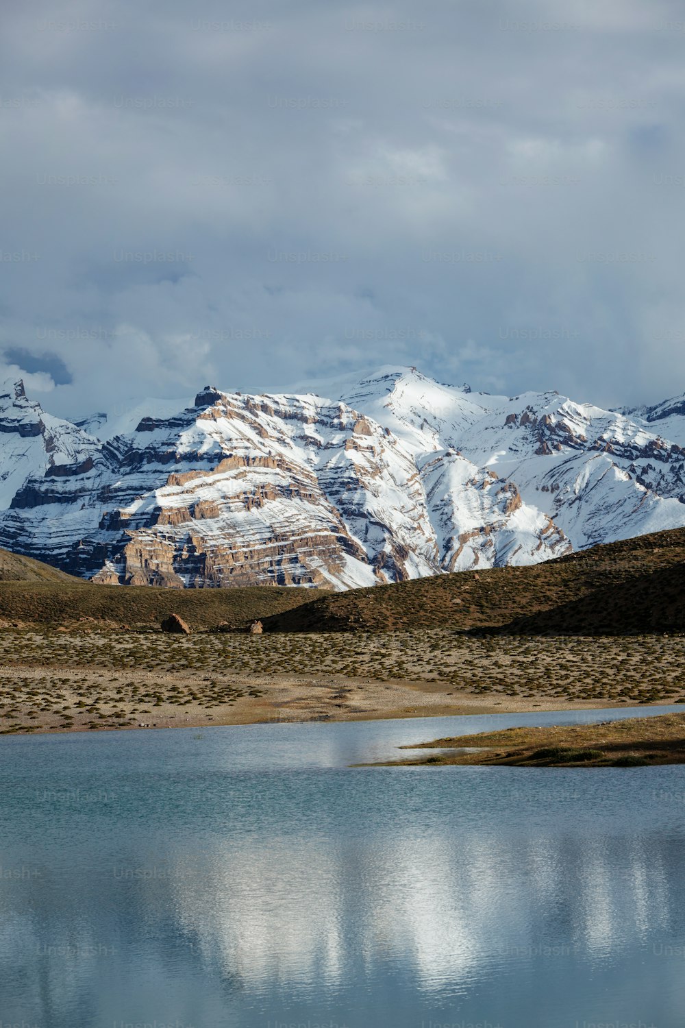 Montagne dell'Himalaya che si riflettono nel lago di montagna Dhankar Lake. Valle dello Spiti, Himachal Pradesh, India