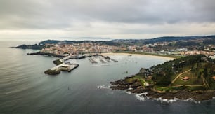 Aerial view of the lighthouse and harbour of Portonovo, a small village in the coast of Galicia, Spain, with the Cies and Ons islands in the background.