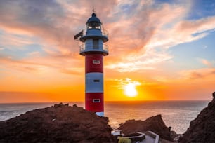 Der wunderschöne Leuchtturm blickt auf einen Sonnenuntergang in Punta de Teno, Teneriffa (Kanarische Inseln)