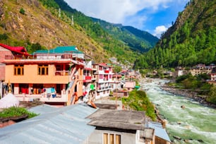 Bunte lokale Häuser und der Fluss Parvati im Dorf Manikaran im Parvati-Tal im Bundesstaat Himachal Pradesh in Indien