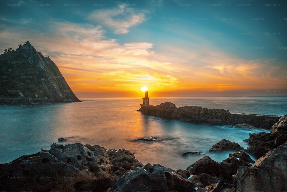 The sun behind the lighthouse at sunset in the town of Pasajes San Juan. Gipuzkoa, Basque Country