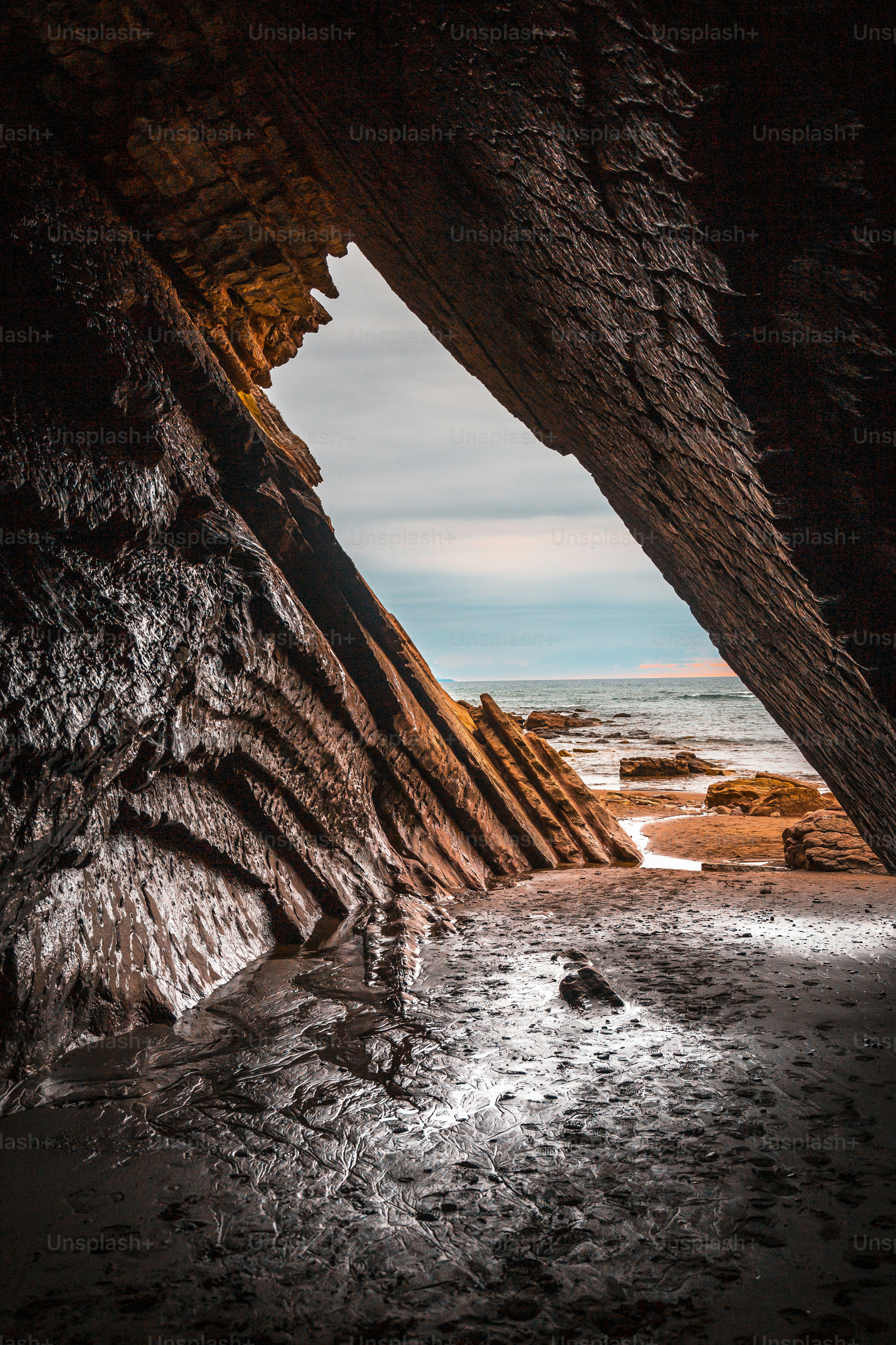 Beautiful natural cave in the flysch of the Itzurun beach in Zumaia, photo in vertical. Basque Country