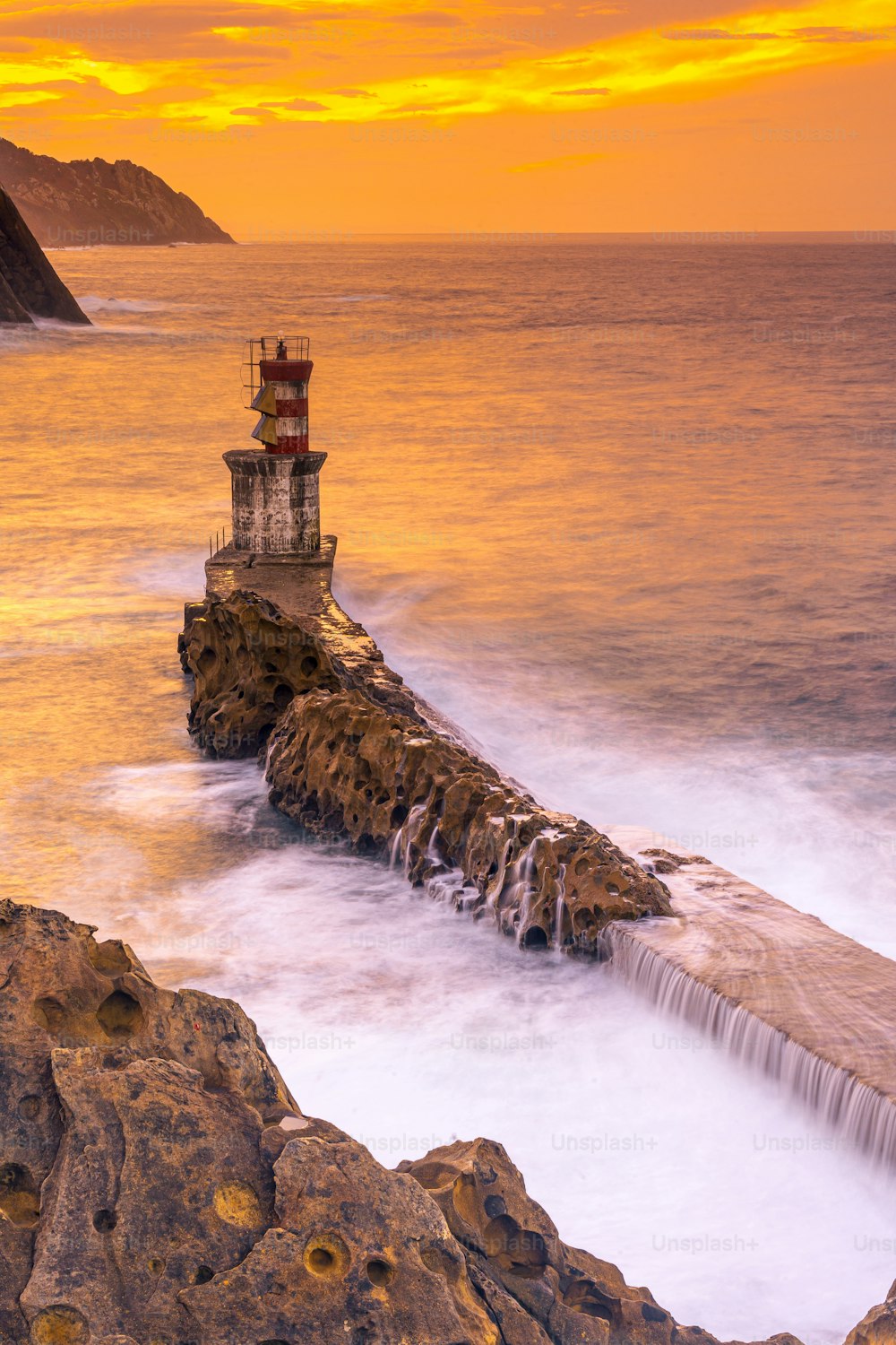 Long exposure in the orange sunset at the lighthouse in the municipality of Pasajes San Juan in Gipuzkoa. Basque Country