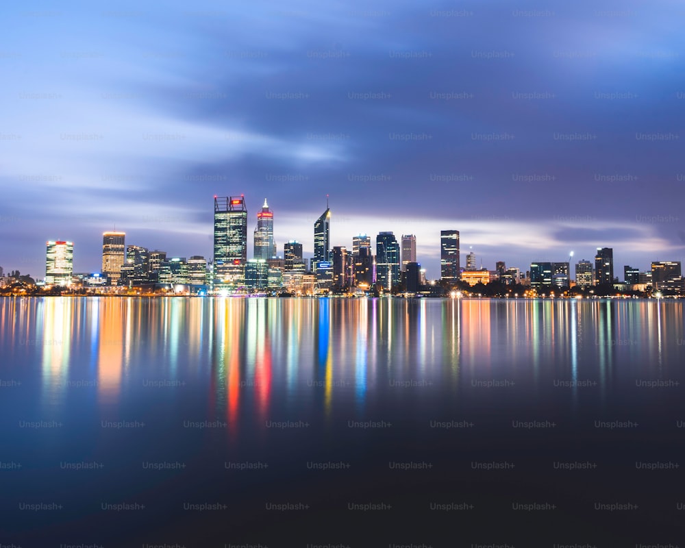 O horizonte de Perth na Austrália Ocidental com as luzes refletidas no lago, longa exposição