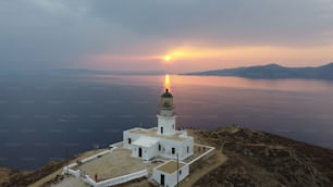 Vista hipnotizante da bela paisagem marítima com farol Armenistis à beira-mar no pôr do sol panorâmico na Grécia