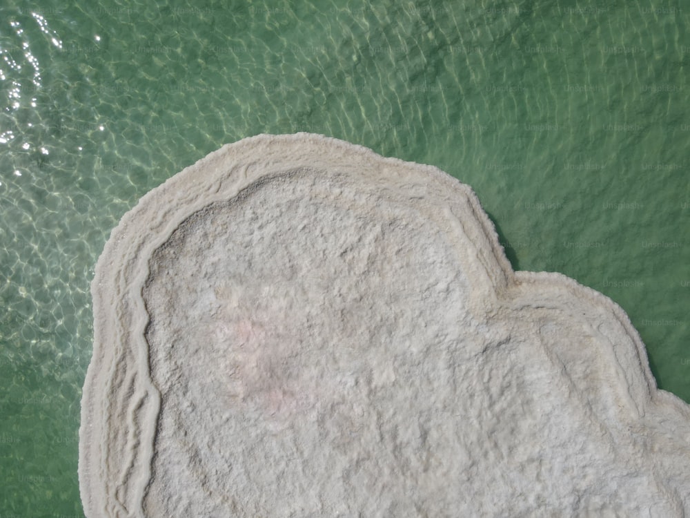 An aerial view of a Salt Island floating over the Dead Sea on a sunny day