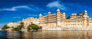 Panorama del famoso hito turístico indio de lujo romántico de Rajasthan - Palacio de la ciudad de Udaipur al atardecer con cielo nublado - vista a nivel de la superficie. Udaipur, Rajastán, India
