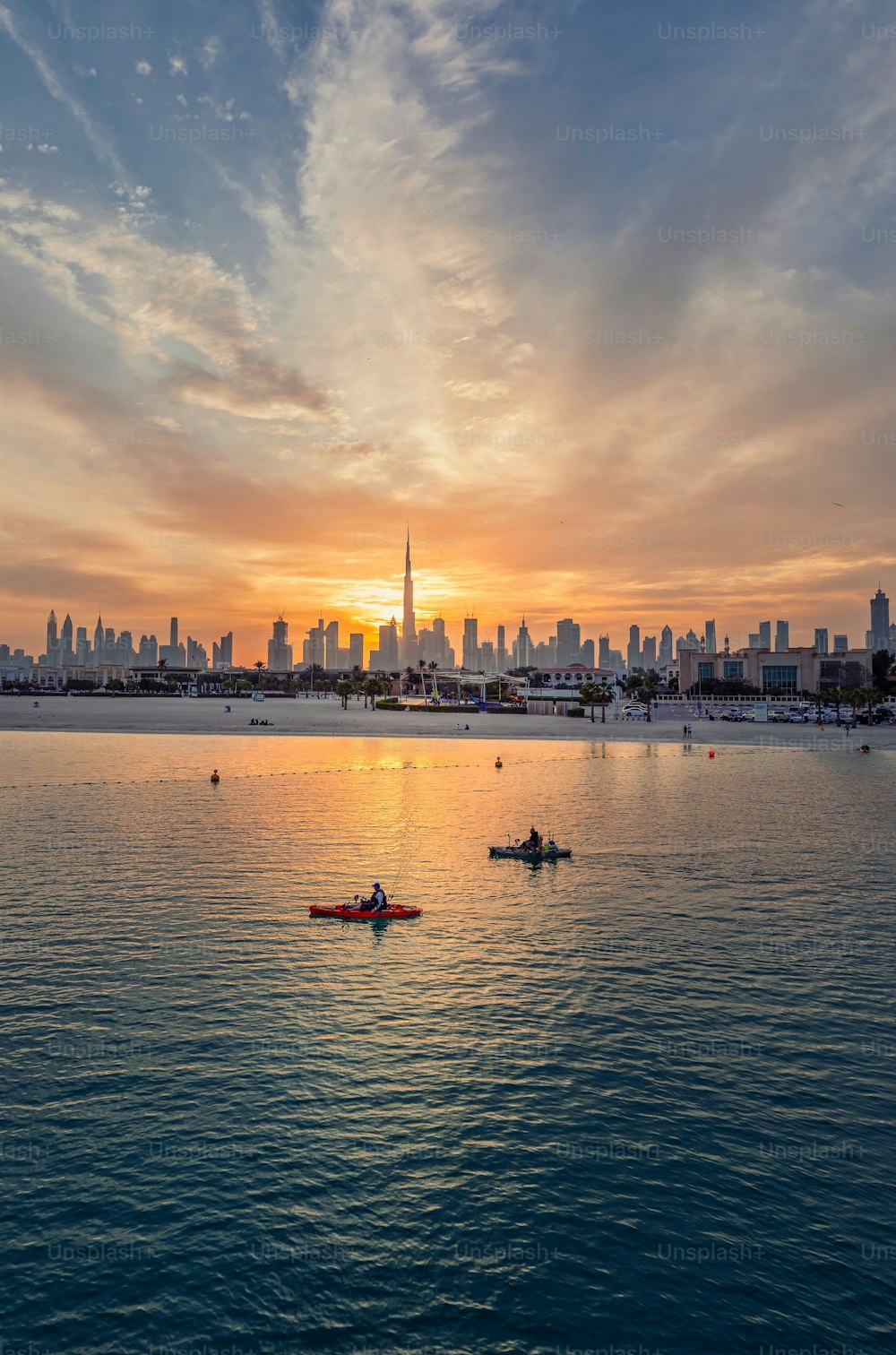A dramatic scenery of a colorful sunset in the cloudy sky over the Dubai cityscape
