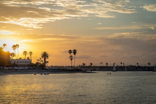 A scenic view of the sunset over a calm coast near shores