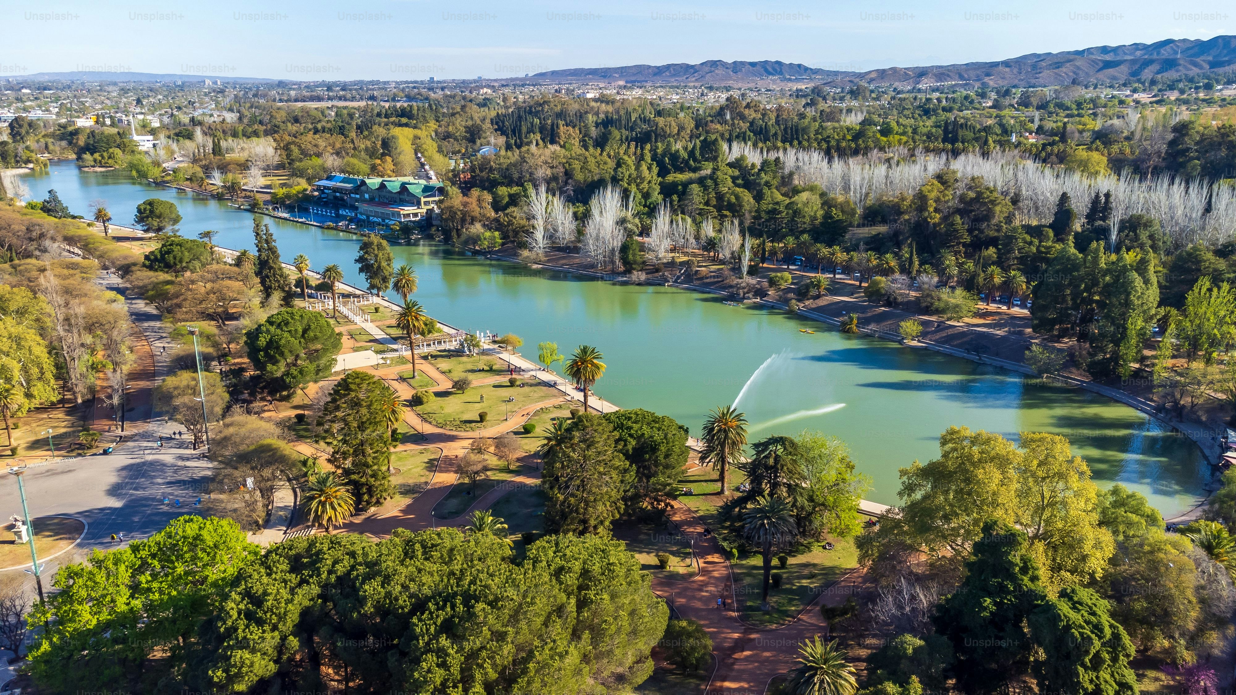 Eine Luftaufnahme des Sees und der Bäume im Parque General San Martin unter blauem Himmel