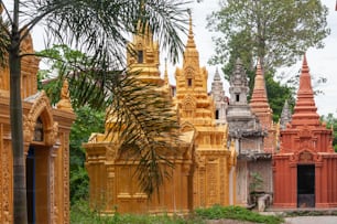 A group of ancient historic religious buildings in the middle of green scenery in Phnom Penh in Cambodia