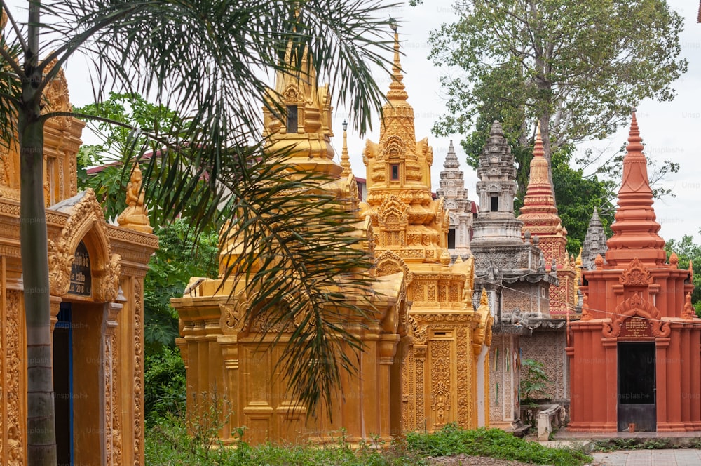 A group of ancient historic religious buildings in the middle of green scenery in Phnom Penh in Cambodia