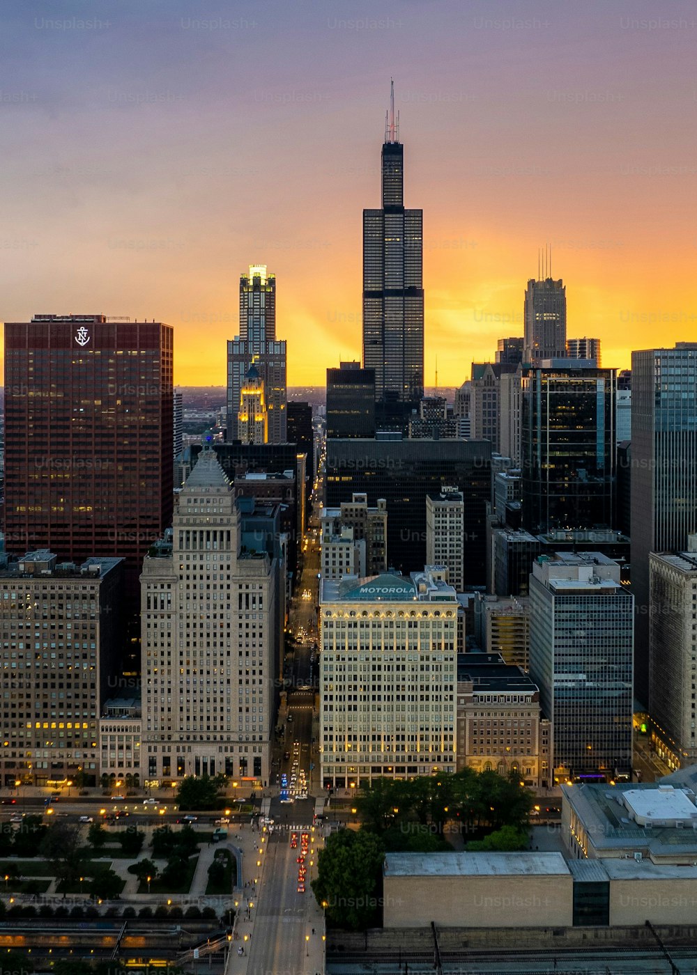 Uma vista aérea do centro de Chicago com arranha-céus altos ao pôr do sol no fundo do céu nublado