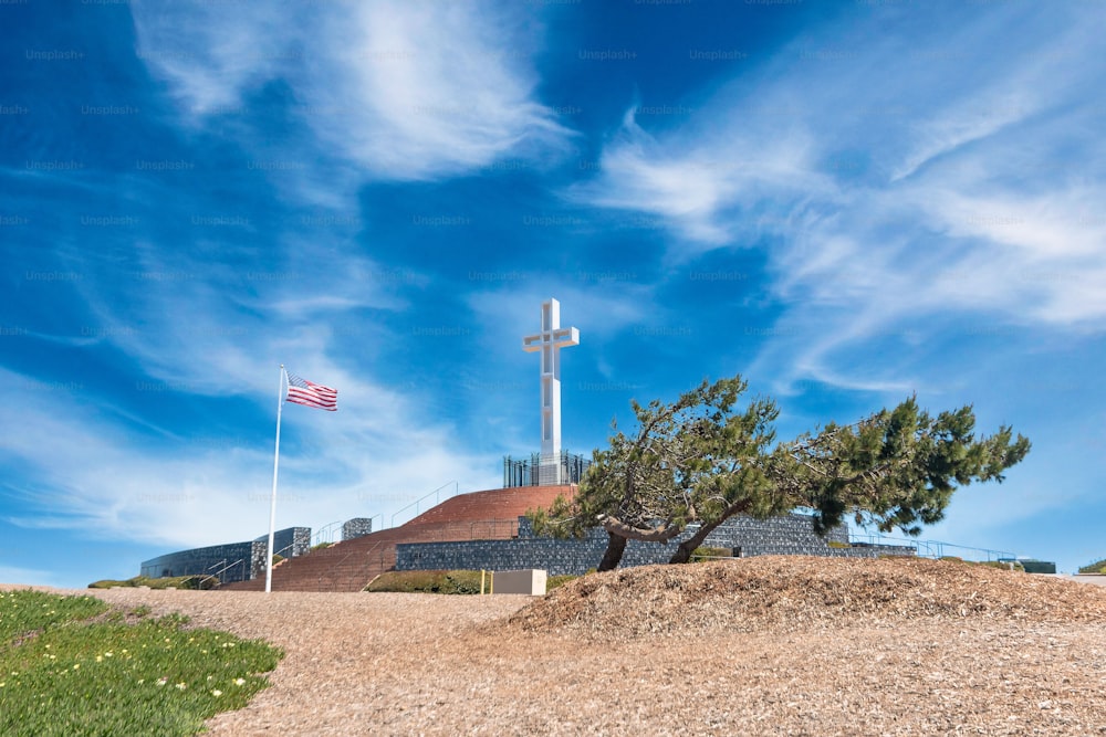 A beautiful shot of the Mt.Soledad National Veterans Memorial with a waving American flag in San Diego