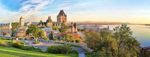A panoramic view of Chateau Frontenac surrounded by greenery in Old Quebec, Canada at sunrise