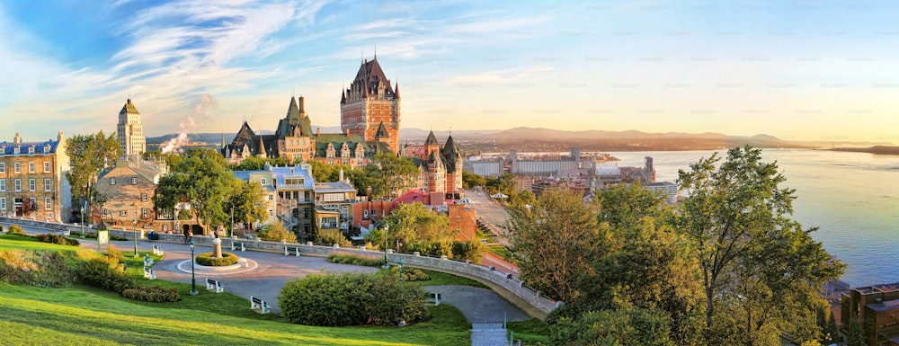 A panoramic view of Chateau Frontenac surrounded by greenery in Old Quebec, Canada at sunrise