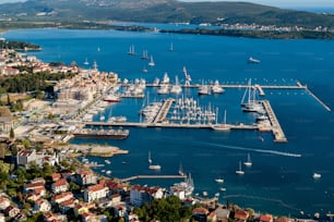 Eine Aufnahme von Booten aus der Vogelperspektive in der Nähe der Docks und Gebäude am Ufer in Porto Montenegro, Kotor, Montenegro
