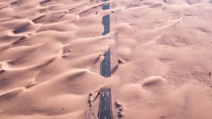 Une autoroute recouverte de sable après une tempête de sable dans un désert des Émirats arabes unis