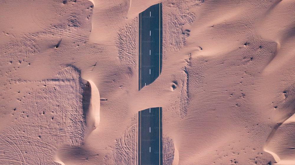An aerial top view of roads through sand dunes in Dubai, UAE