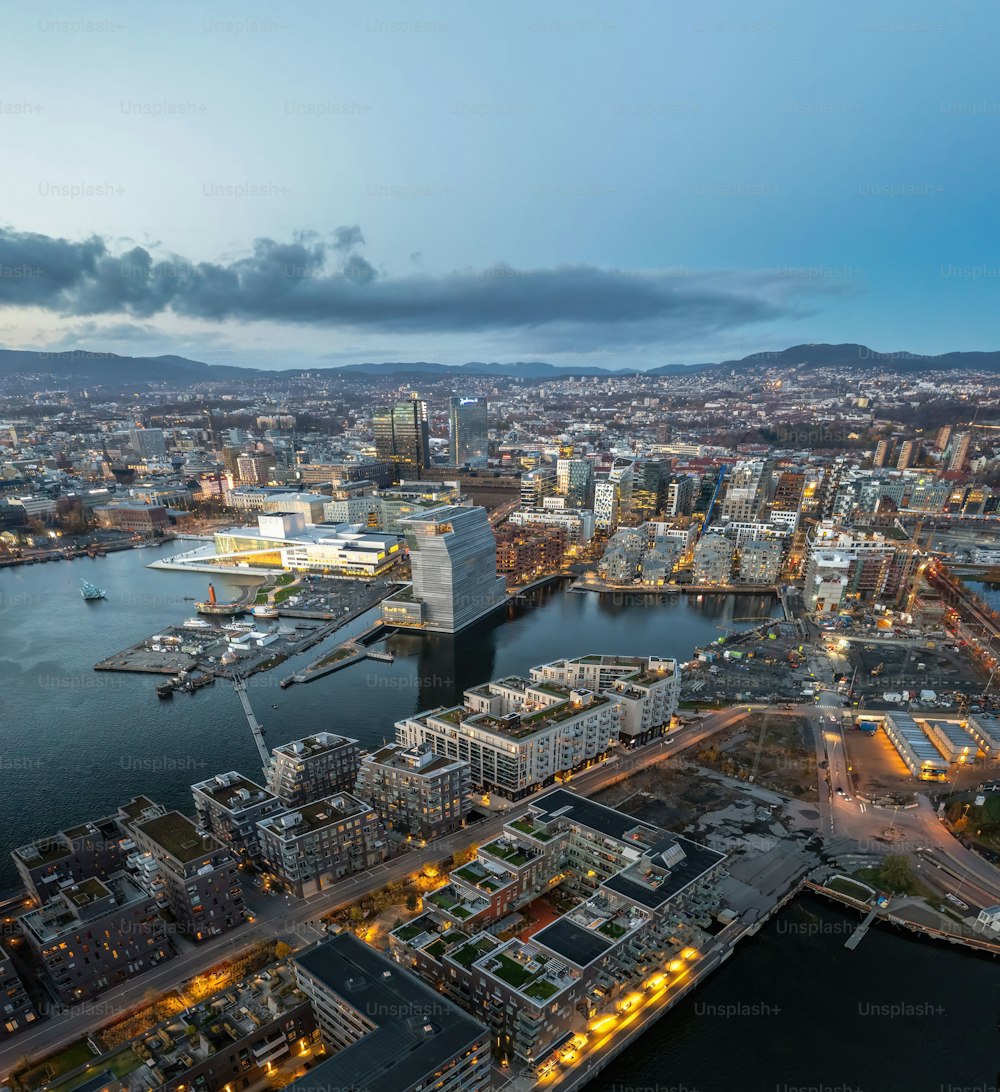 An aerial shot of Oslo at sunset, with lots of buildings and lights, surrounded by sea, Norway