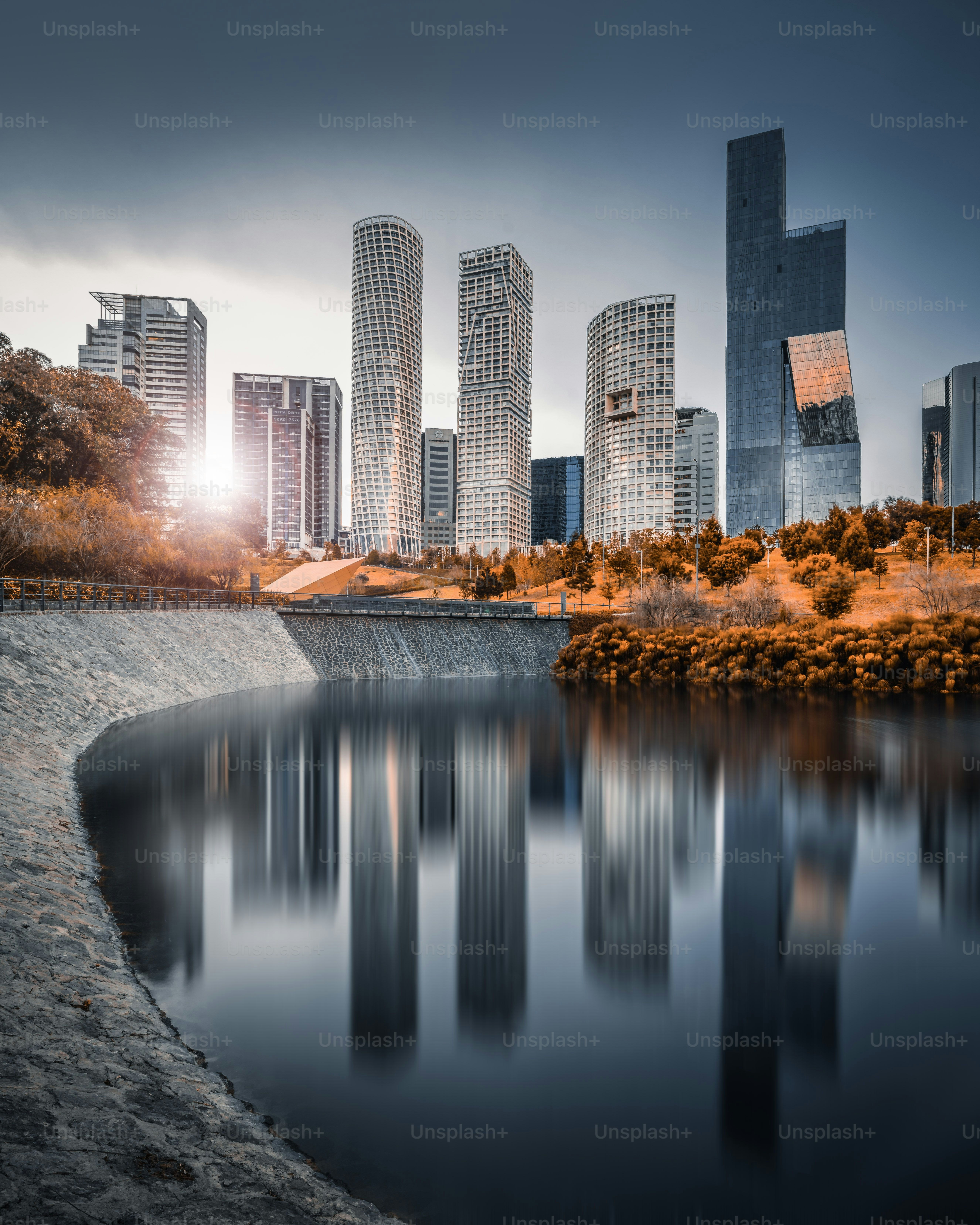 Meraviglioso skyline con enormi grattacieli e un bel tramonto sullo sfondo riflesso in un lago