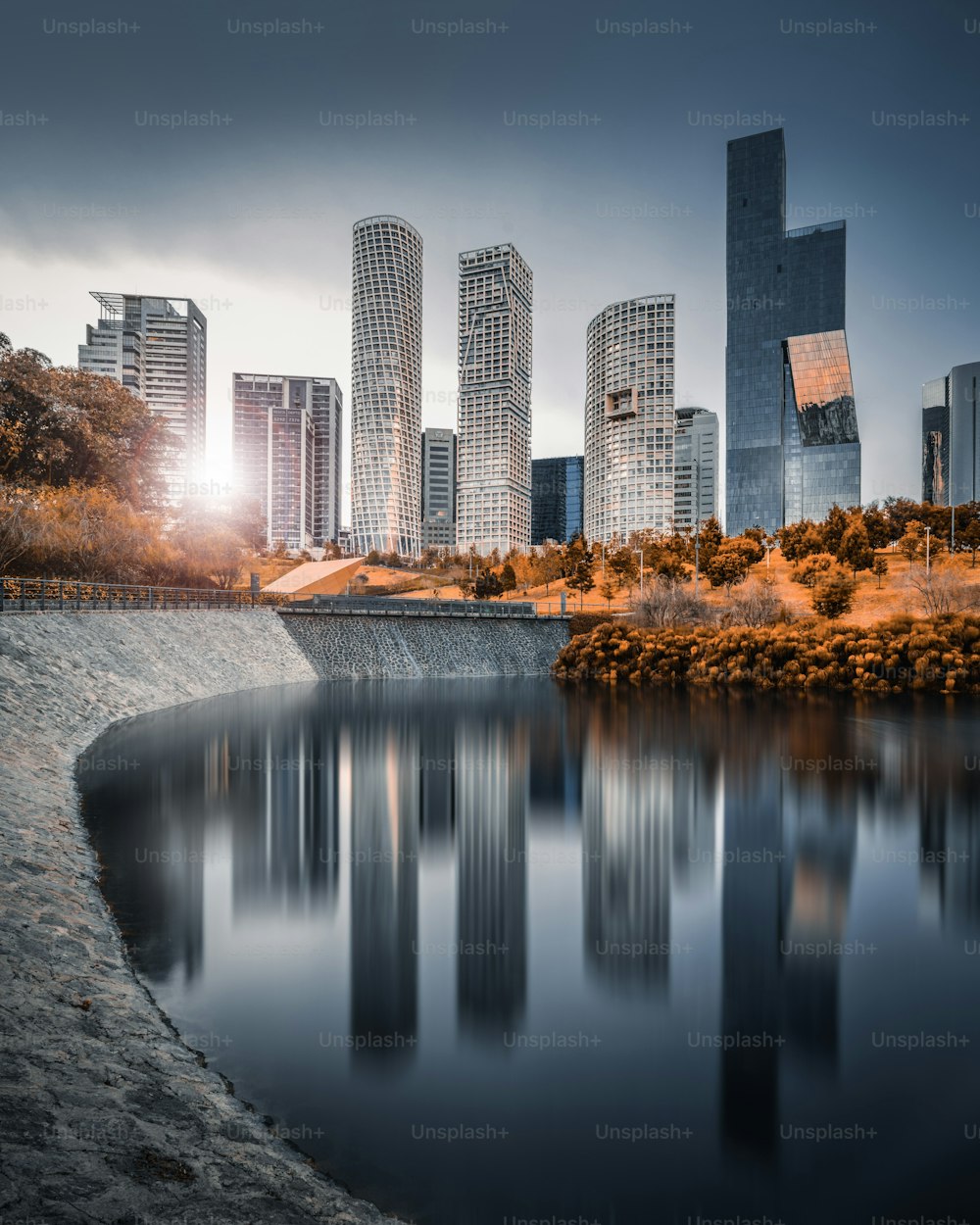 Wonderful skyline with huge skyscrapers and a nice sunset in the background reflected in a lake