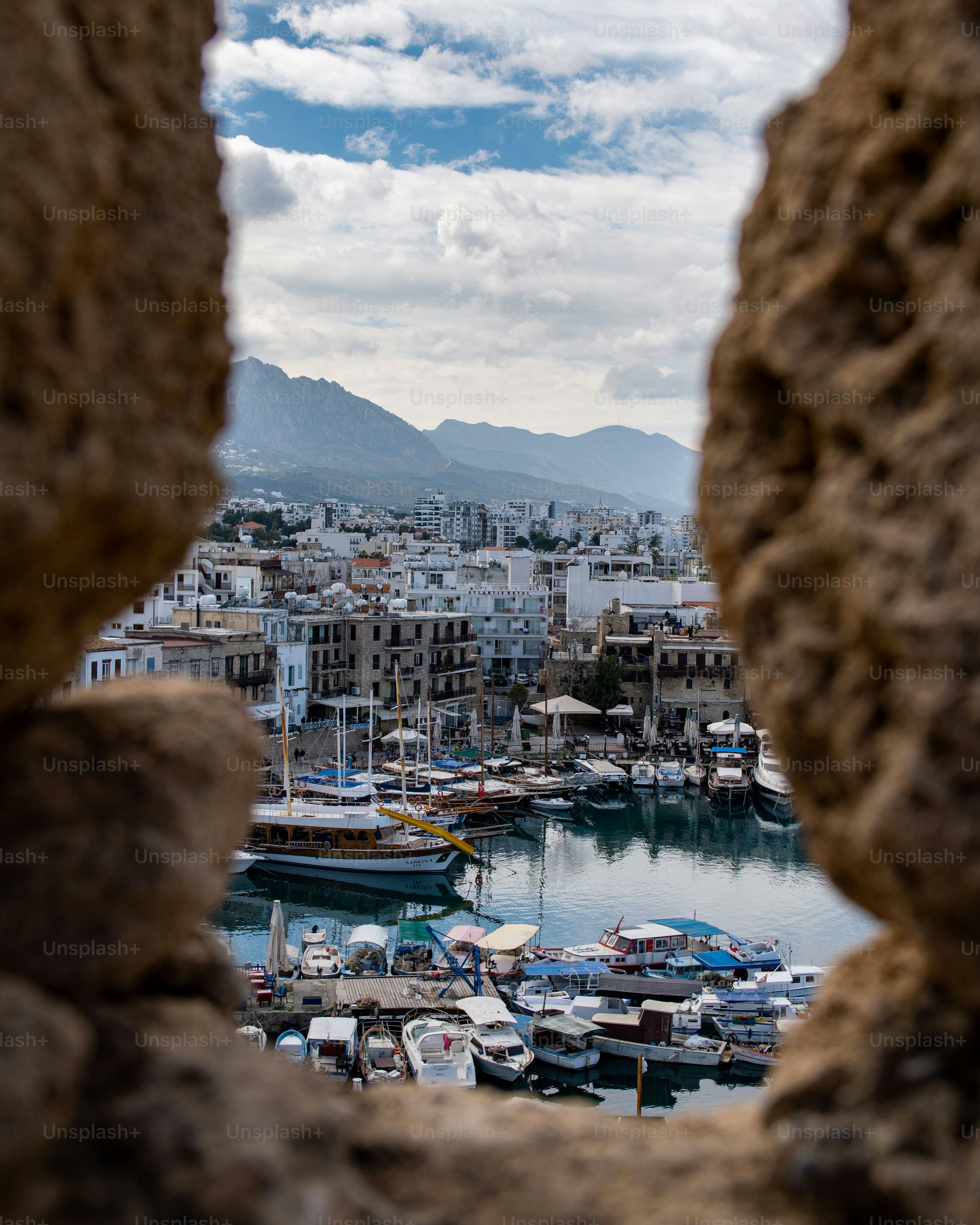 Ein malerischer Blick auf den historischen Hafen von Kyrenia durch das Steinfenster der Burg von Kyrenia