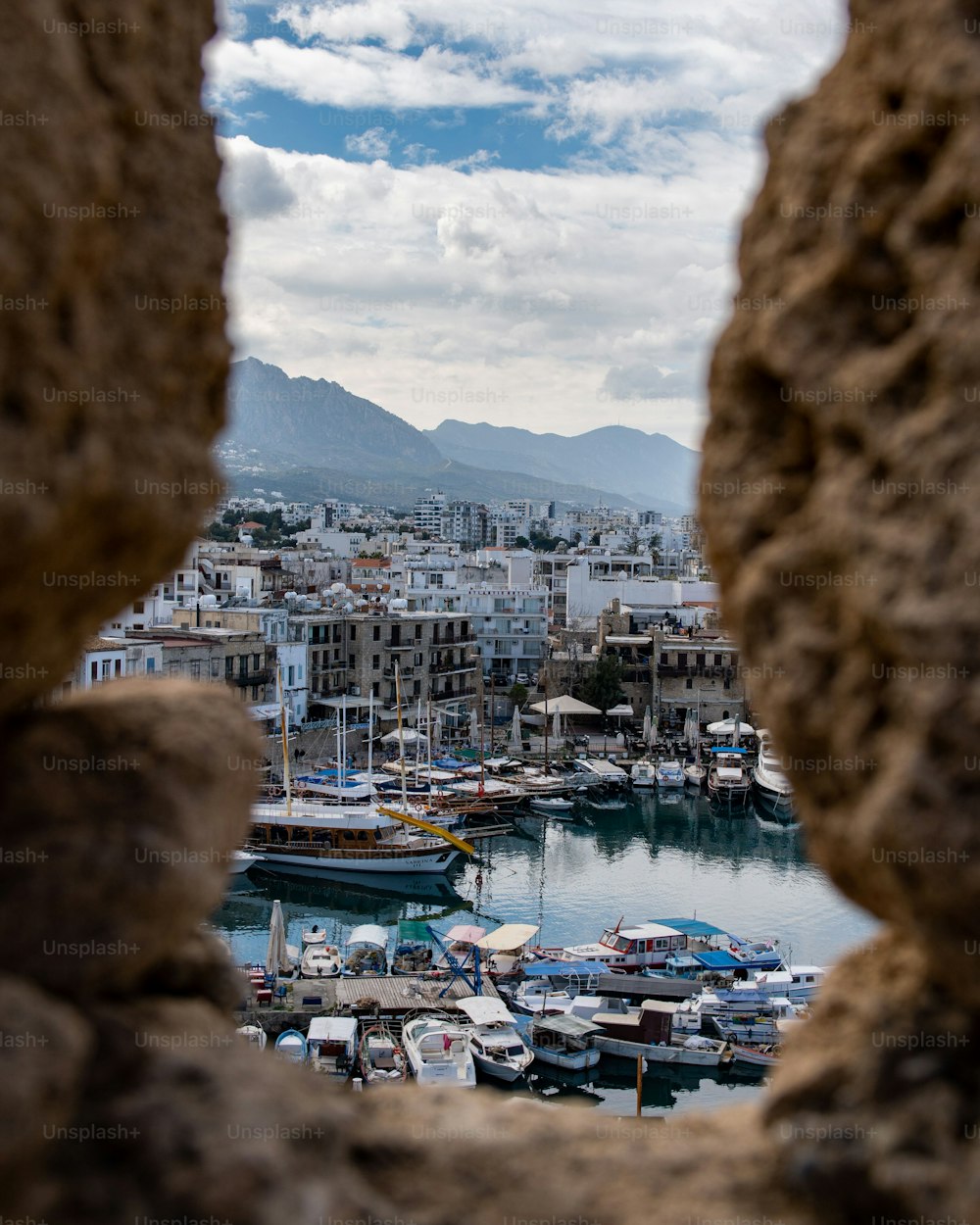 Uma vista panorâmica de um porto histórico de Kyrenia através da janela de pedra do castelo de Kyrenia