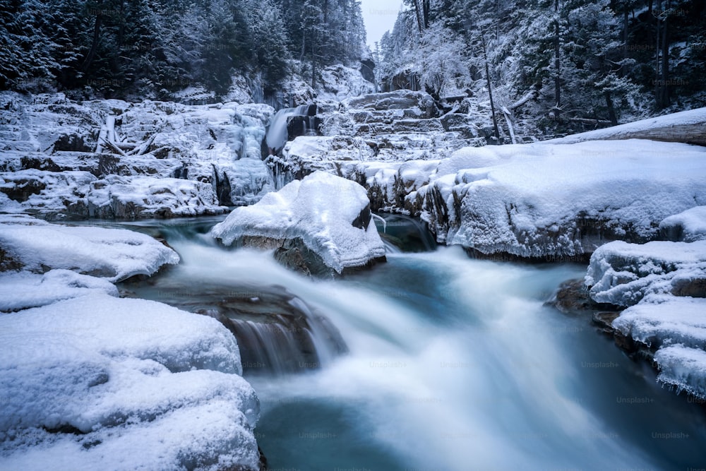 Scenic view of frozen waterfall surrounded by rocks in cold winter day in Myra falls Vancouver Island BC Canada