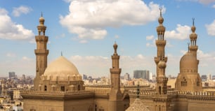 Los minaretes y las cúpulas de la mezquita del sultán Hassan y la mezquita de Al Rifai, El Cairo, Egipto sobre un fondo de cielo nublado