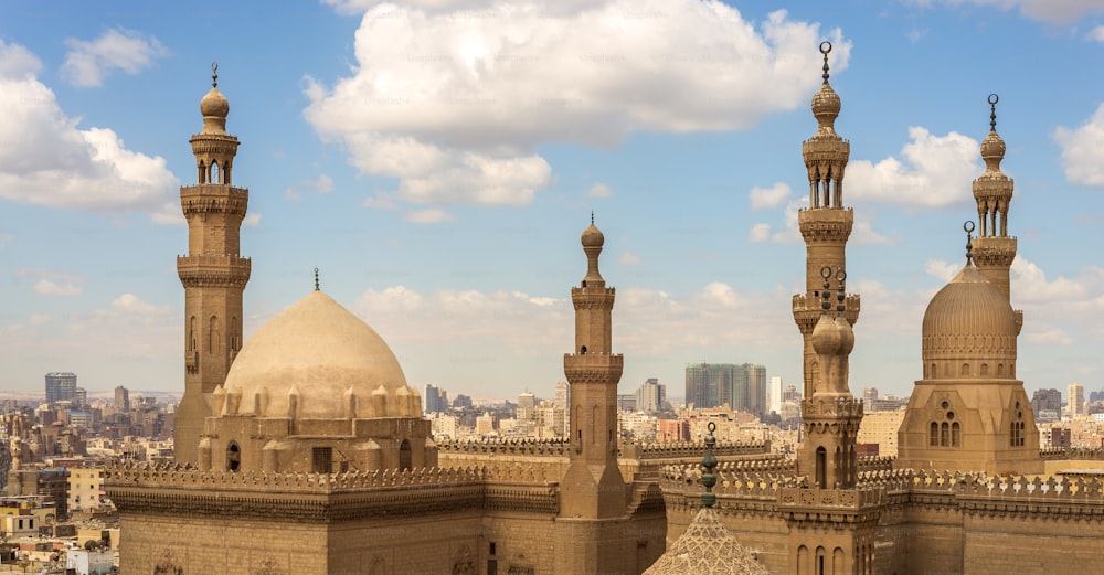 曇り空の背景にスルタンハッサンモスクとアルリファイモスクのミナレットとドーム、カイロ、エジプト